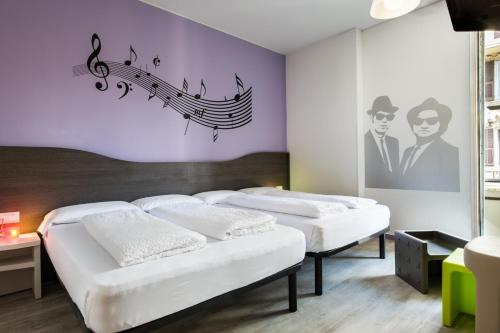 热那亚纳罗格酒店的墙上有音乐音符的房间的三张床
