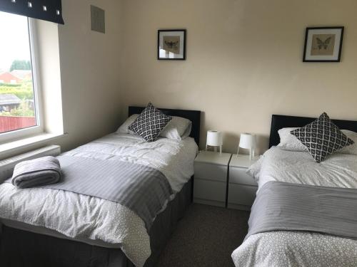 特尔福德8 Pickering Road的一间卧室设有两张床和窗户。