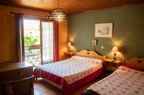 圣马丹韦叙比耶Hotel Relais Saint Louis的一间卧室设有两张床和窗户。