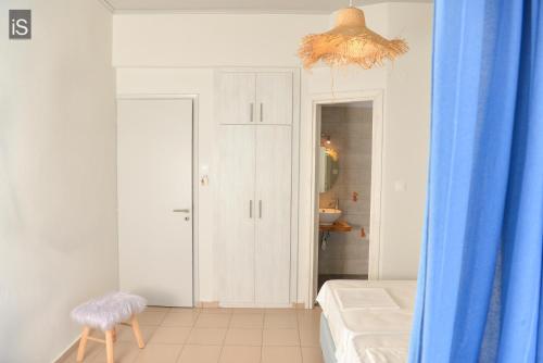 费索斯SEA VIEW ROOMS Afissos的浴室设有床和蓝色窗帘