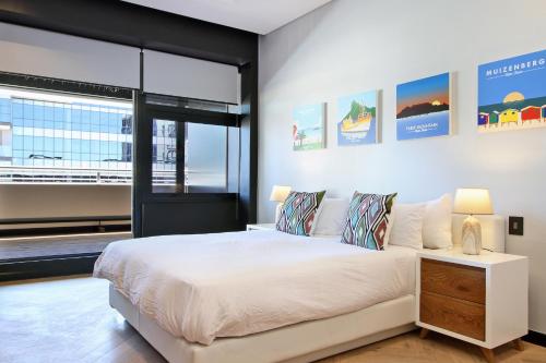 开普敦Penthouse Henning@The Onyx的卧室设有白色的床和大窗户