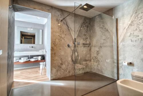 马里纳迪马萨埃尔莎别墅酒店的带淋浴的浴室和玻璃门