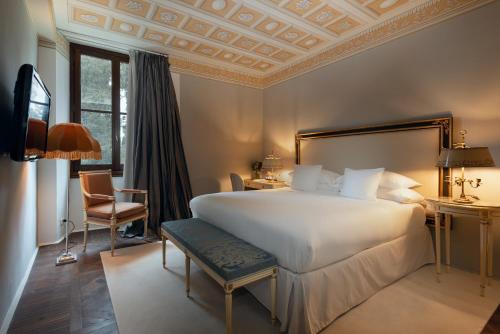 佛罗伦萨Il Salviatino Firenze的卧室配有一张白色大床和一把椅子