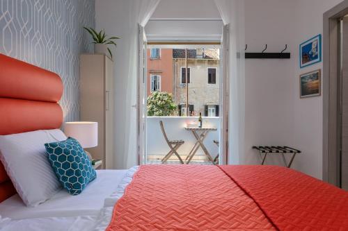 普拉La Preziosa Rooms的一间带红色床的卧室和一个阳台