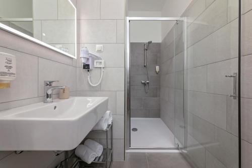 普拉La Preziosa Rooms的白色的浴室设有水槽和淋浴。