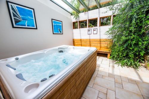 BervilleLa Ferme de L'Oudon & SPA的植物间的大浴缸