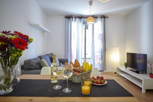拉斯加莱塔斯Apartamento Sol y Mar I的客厅配有一张桌子,提供一篮水果和酒杯