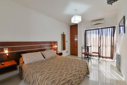 上格拉西亚丽兹酒店的卧室配有1张床、1张桌子和1把椅子