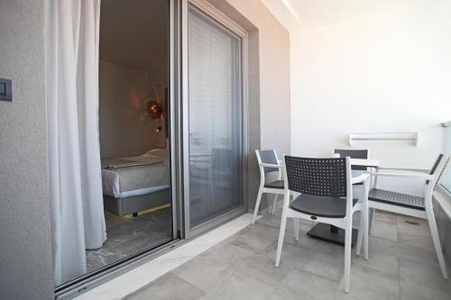 卡尼奥提Athinais Luxury Apartments的一间带桌椅的房间和一间卧室