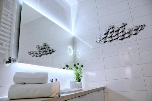 米兹多洛杰Onyx Aquamarina by Baltico Apartament的白色的浴室设有水槽和镜子