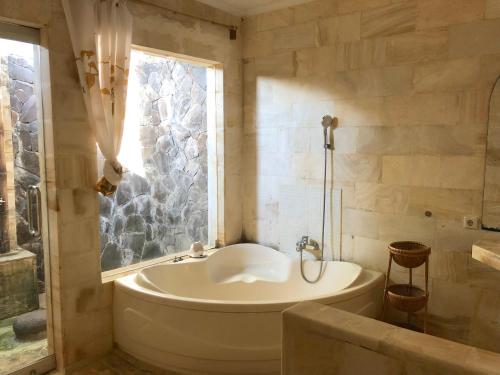 金巴兰Bale Asri Bukit Jimbaran的带浴缸的浴室和窗户