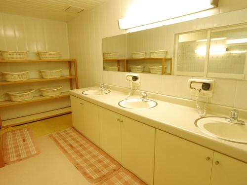 小谷村阳光谷酒店 的一间带两个盥洗盆和大镜子的浴室