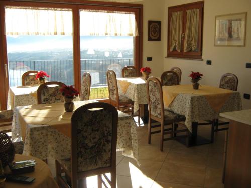Revò阿格里图威斯达拉戈住宿加早餐旅馆的一间带桌椅的用餐室和窗户。