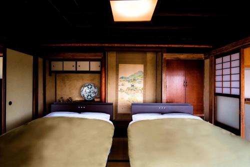 福山そわか楼的带2扇窗户的客房内的2张单人床