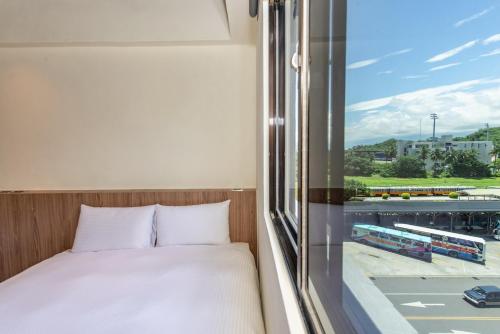 台东旅人驿站铁花文创二馆的一间卧室设有一张床和一个美景窗户。