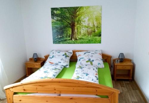 瓦尔德基尔希Ferienwohnung Am Eichbühl的一间卧室配有一张木床,墙上挂着一幅画作