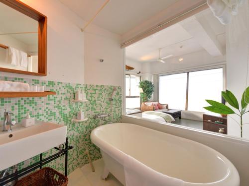 南房总市Sound Swell Resort的带浴缸、水槽和镜子的浴室