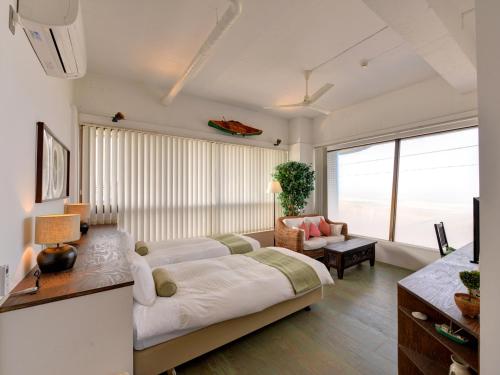 南房总市Sound Swell Resort的客厅配有大床和沙发