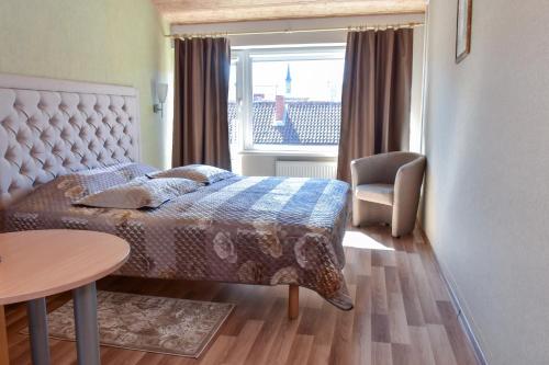 克莱佩达艾斯马尔斯酒店的一间卧室配有一张床、一张桌子和一个窗户。