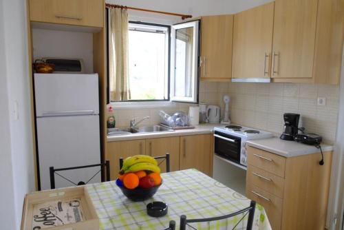 爱琴娜岛Marathona's Apartment的厨房配有一张桌子,上面放着一碗水果