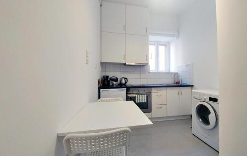 雅典KYMA Apartments - Athens Acropolis 2的白色的厨房配有桌子和洗衣机。