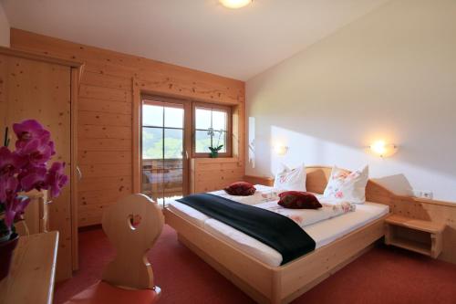蒂罗尔-基希贝格Gasthaus Obergaisberg的一间卧室配有一张带白色床单的床和一扇窗户。