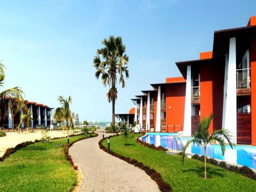 萨拉昆达African Princess Beach Hotel的一个带游泳池和棕榈树的度假村