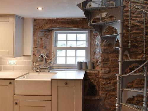 塞德伯secret cottage的一个带水槽和石墙的厨房