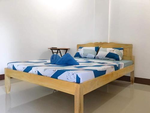 安达Za Priscila Tourist Inn的一张铺有蓝色和白色床单的木床