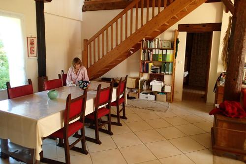 MomuyRicouch, chambre d'hôtes et permaculture的坐在饭厅桌子上的女孩