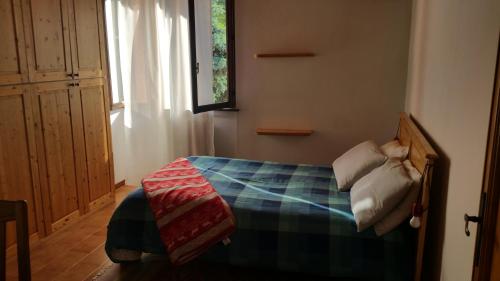 圣奥莫波诺伊马加I Tre Ciliegi Apartment的一间卧室配有一张带铺着地毯的床和窗户。