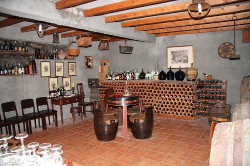 桑塔纳Refúgio das Camélias的酒吧配有桌子和一些葡萄酒