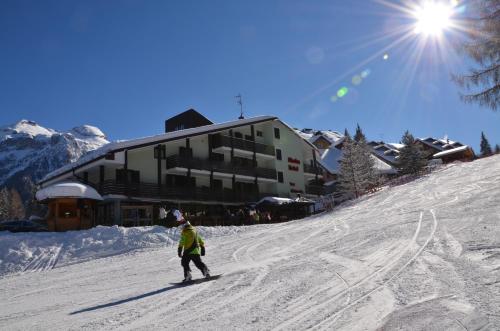 佛加里达阿拉斯加酒店的骑着滑雪板沿着雪覆盖的斜坡滑雪的人