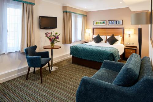 格拉茨克洛斯公牛酒店的酒店客房,配有一张床和两把椅子