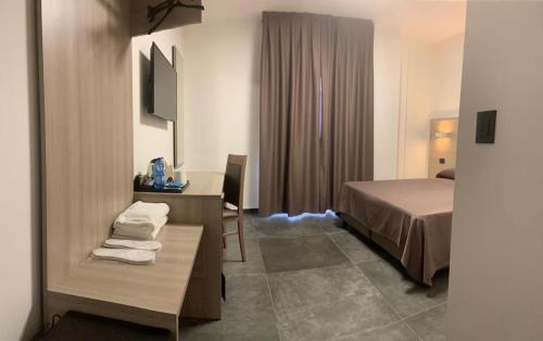 摩德纳奇碧酒店的酒店客房配有一张床铺、一张桌子和一张书桌。
