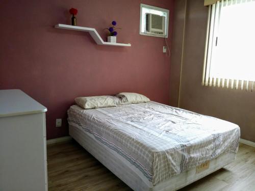 里约热内卢Apartamento Vila DR - Barra da Tijuca,prox Jeunesse,Arenas,Rio Centro,praias, Shopping的一间卧室设有一张床和红色的墙壁