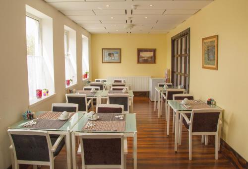 布特尔微风宾客酒店的用餐室设有桌椅和窗户。