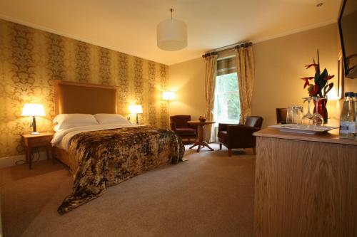 普雷斯顿法灵顿旅舍酒店的酒店客房带一张床、一张桌子和椅子