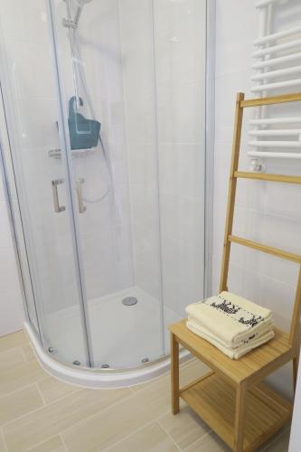 科沃布热格Biały apartament的带淋浴和木凳的浴室