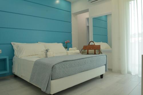 特罗佩阿Dreams Tropea Mare的一间卧室配有一张大床和蓝色床头板