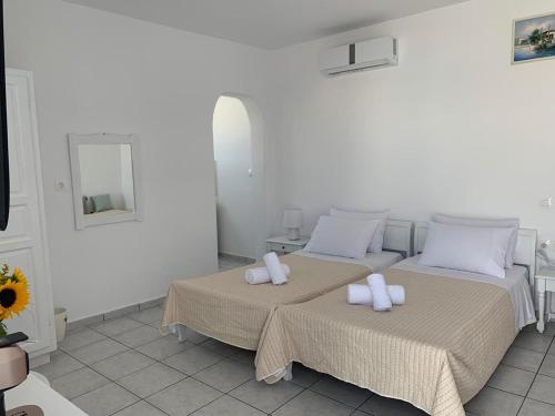 克洛瓦斯Fortina Mykonos house的白色客房内的两张床和毛巾