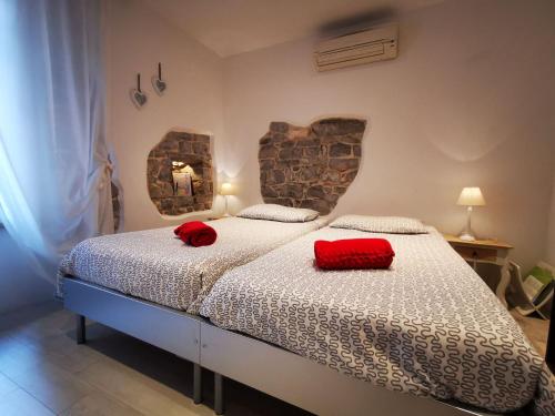 洛夫兰ROMANTIC APARTMENT Lovran - 4 stars的一间卧室配有一张带两个红色枕头的床