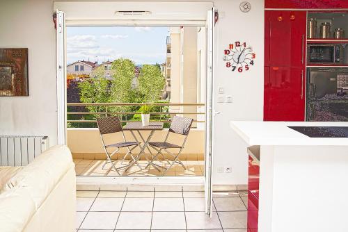 德希内斯·尚皮埃Appart'cosy Lyon Est的厨房设有带桌椅的阳台