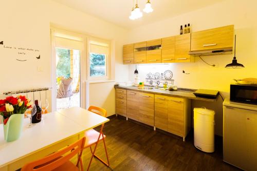 DekaniMoments Apartment的一间带木制橱柜和桌子的厨房以及一间用餐室
