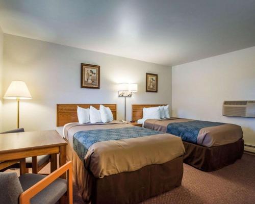 圣奥尔本斯Econo Lodge的酒店客房设有两张床和一张桌子。
