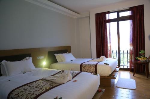 贡德尔Haile Resort-Gondar的酒店客房设有两张床和窗户。