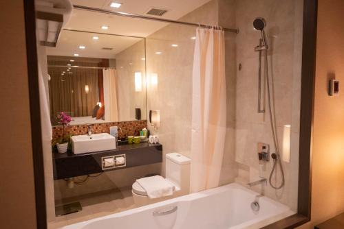 新加坡新加坡柏薇樟宜酒店的带浴缸、水槽和镜子的浴室