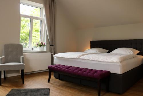 伯格奥夫费马恩Stadt Apartments Burg Fehmarn的一间卧室配有一张大床和紫色长凳