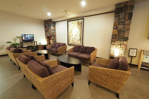 屋久岛屋久岛绿色酒店的带沙发、椅子和电视的等候室