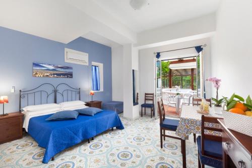 索伦托Sorrento Marida Rooms的一间带蓝色床的卧室和一间用餐室